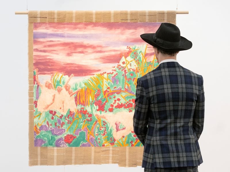 A male model lookinh at the art during Frieze Art Fair